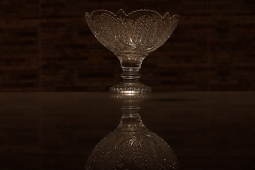 Elegant Murano glass bowl with delicate patterns, displayed on a wooden table in warm light.