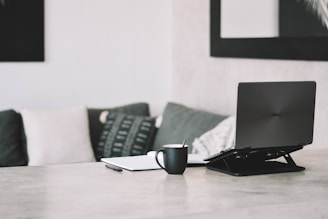 A clean and modern workspace featuring a laptop, notebook, and coffee cup, ideal for blogging.