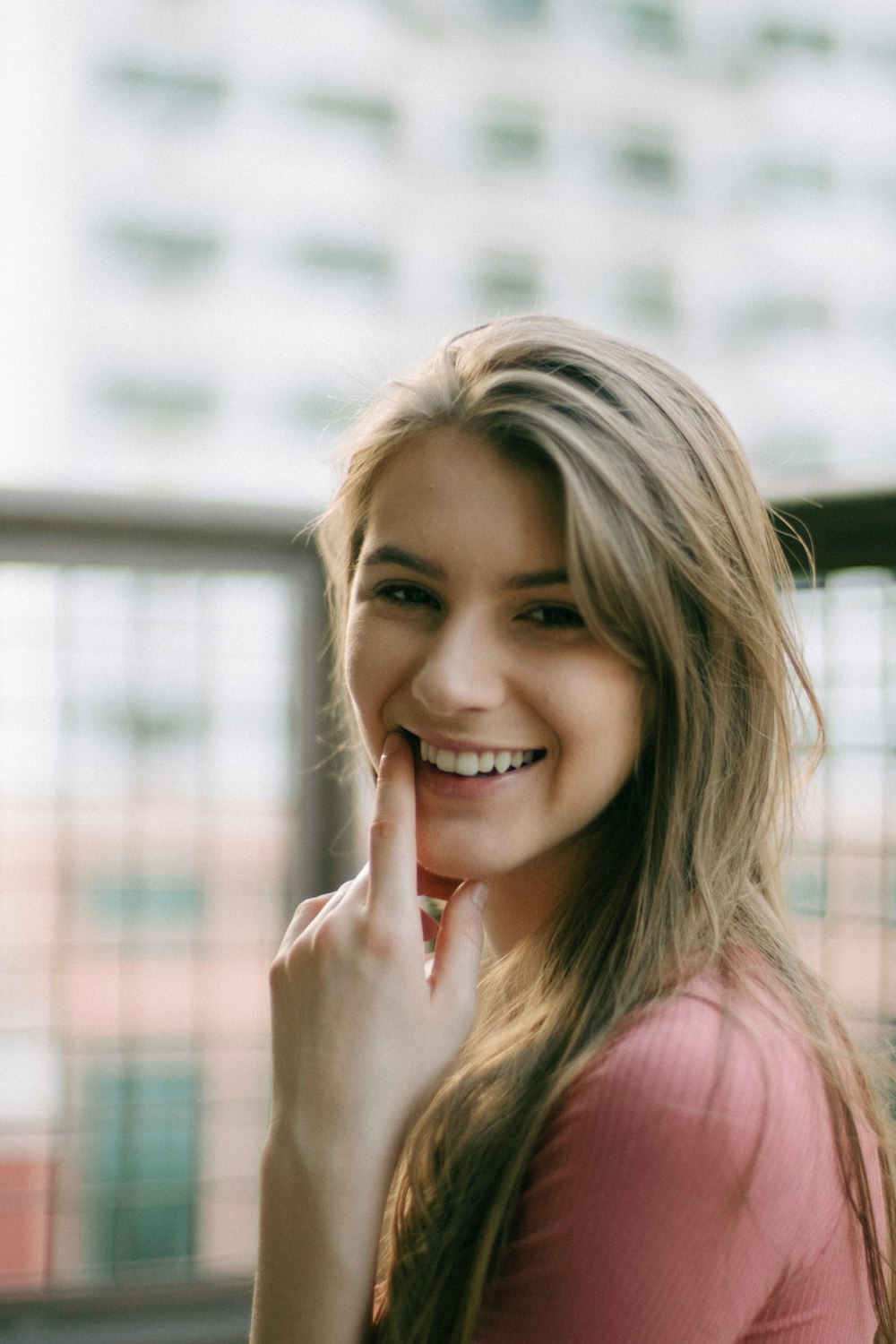 femme en débardeur rose souriant