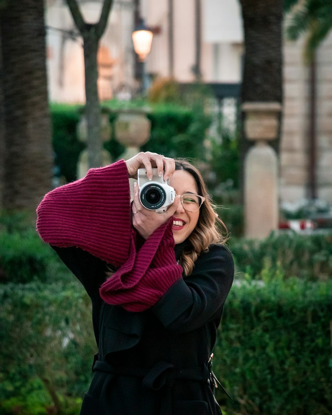 woman in red sweater holding camera