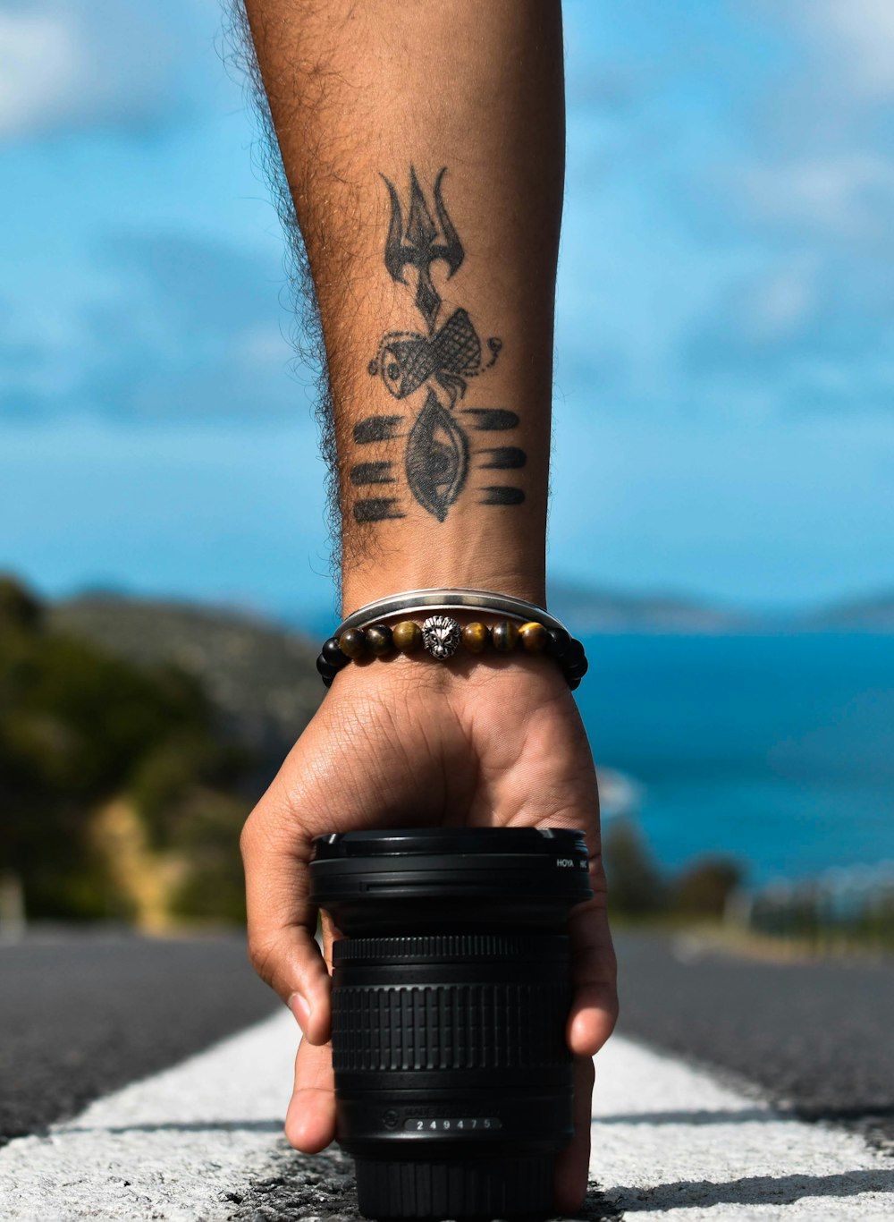person with black and brown tattoo on arm