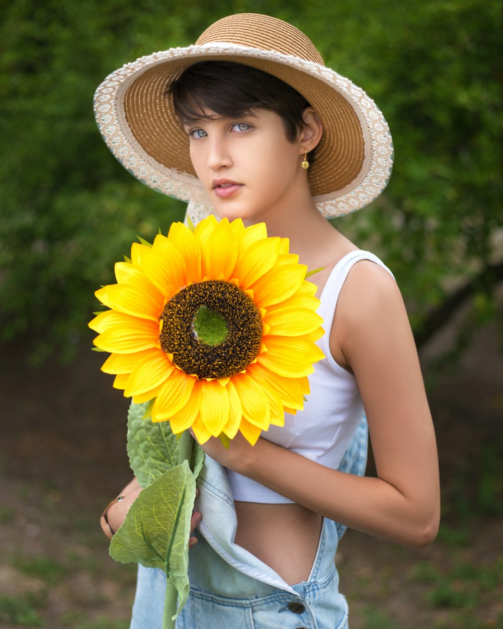 woman in yellow sleeveless dress holding sunflower