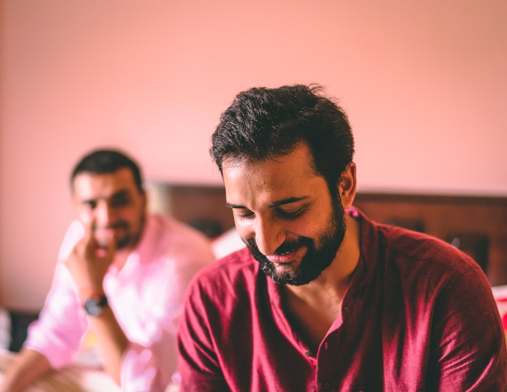 man in red crew neck shirt sitting beside woman in white shirt