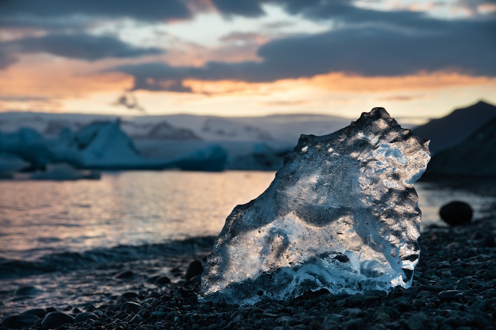 ice on black rocky shore during daytime