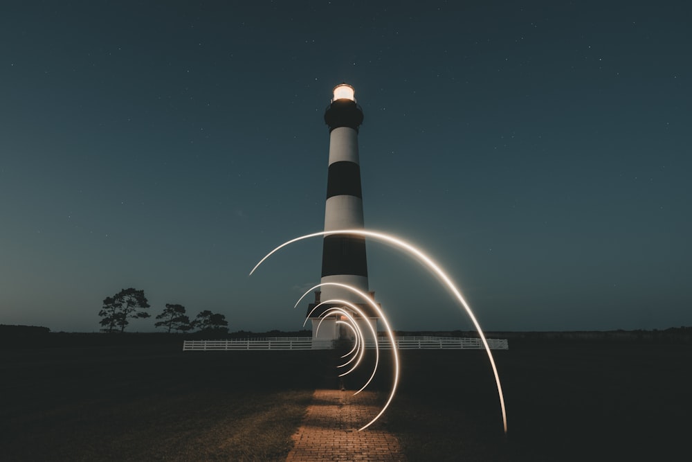 white and black light house under blue sky during night time