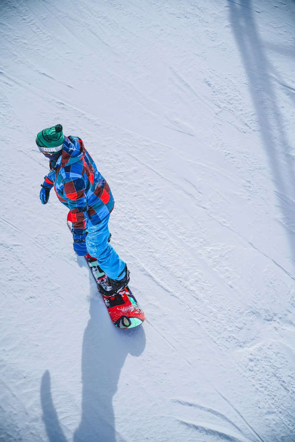 person in blue red and white jacket and pants riding ski blades on snow covered ground