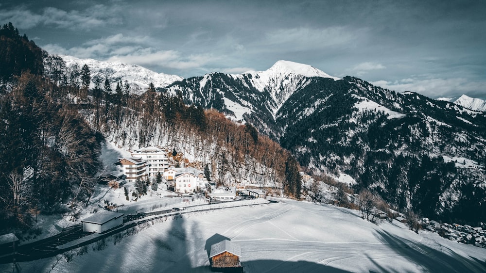 brown house on snow covered ground near snow covered mountain during daytime