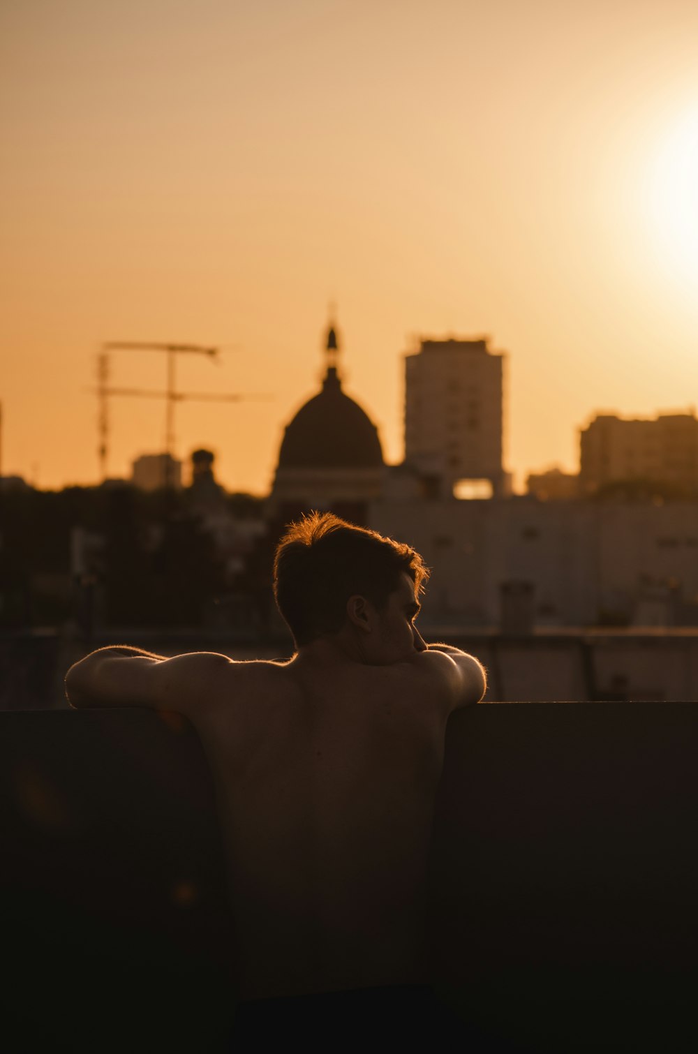 topless woman sitting on black chair during sunset