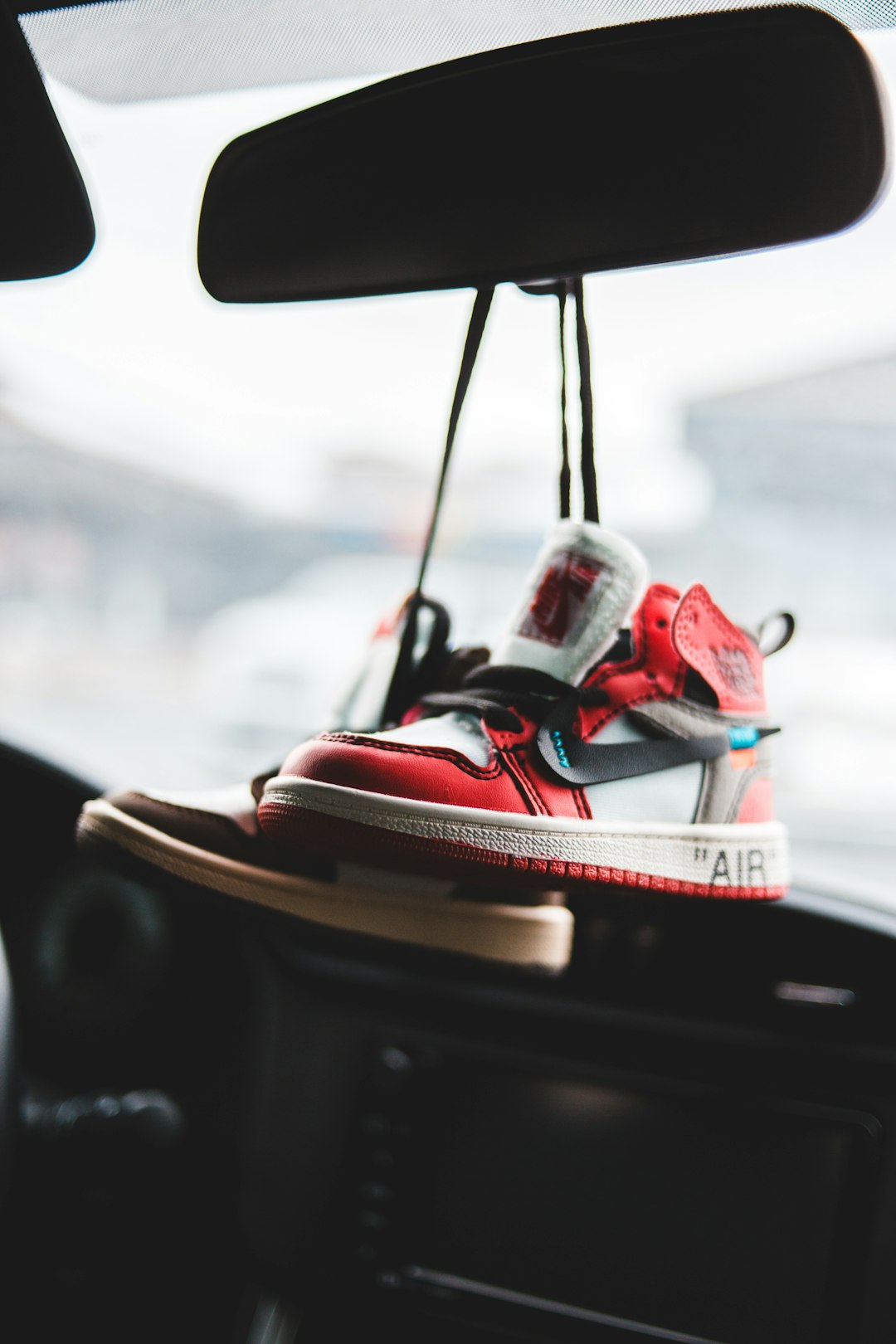 red and white nike sneakers on car dashboard