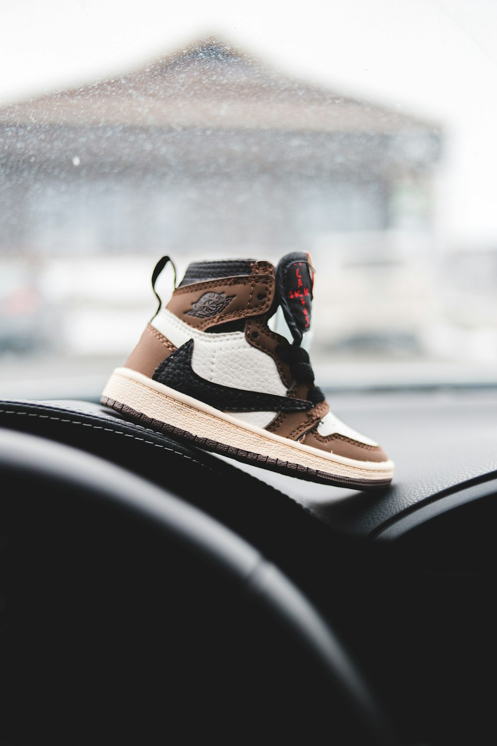 brown and black nike shoes on car dashboard
