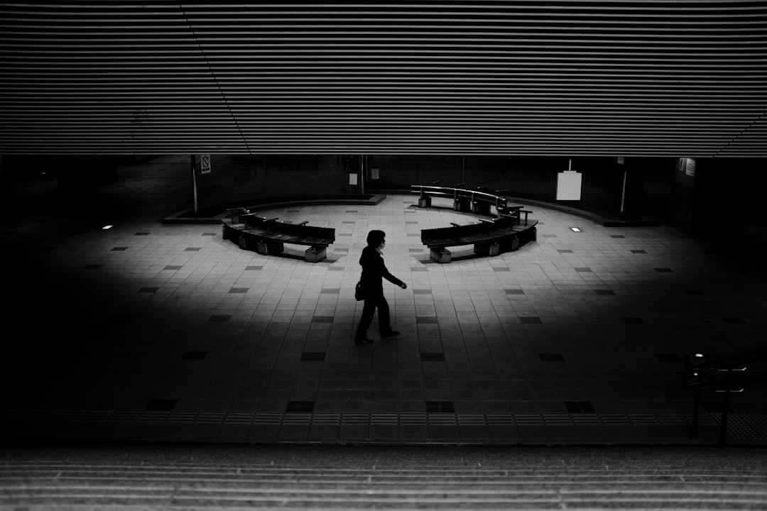 silhouette of person walking on sidewalk during night time