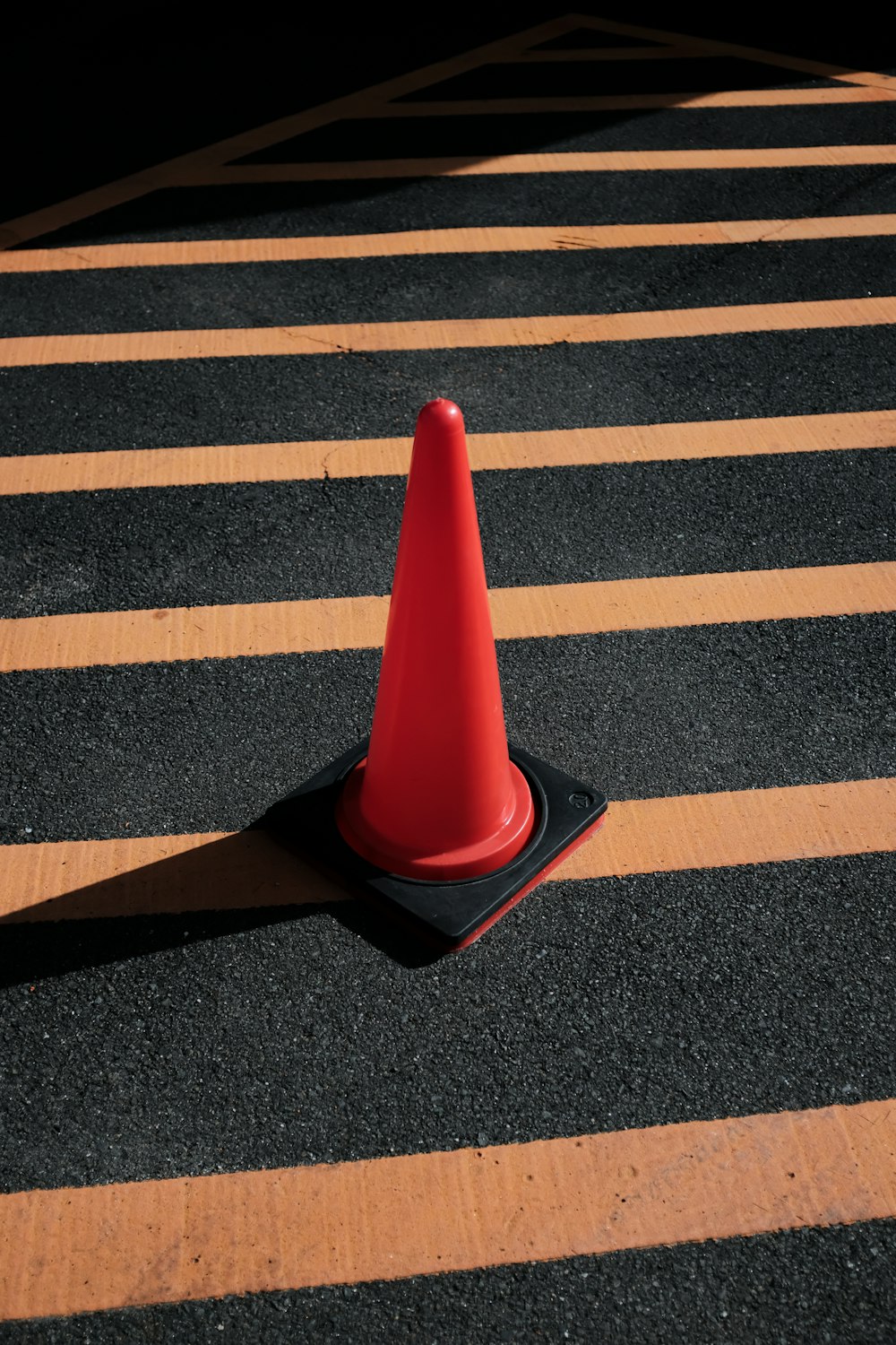 red and black traffic cone on black and white stripe floor