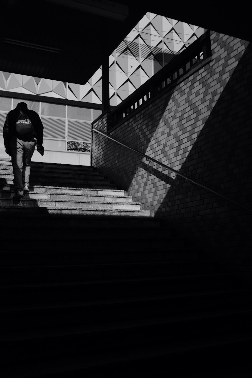 homem de camisa preta e calças andando em escadas