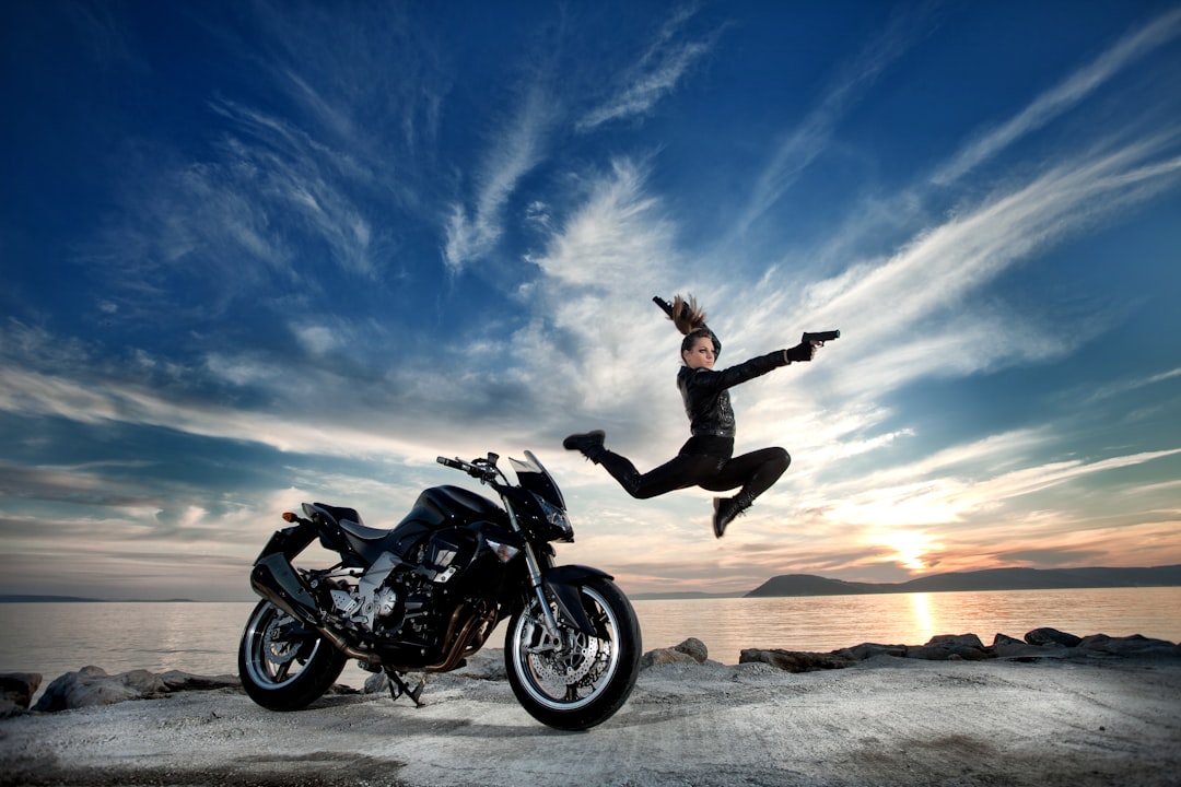 man in black jacket and black pants riding black motorcycle on brown sand during daytime