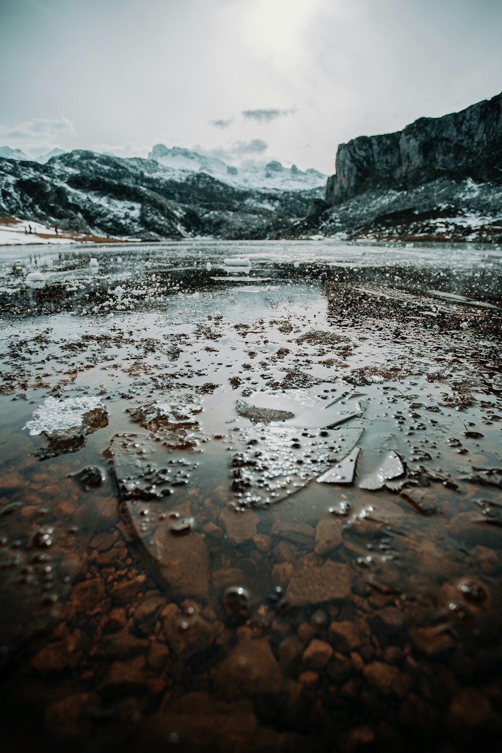 body of water near mountain during daytime