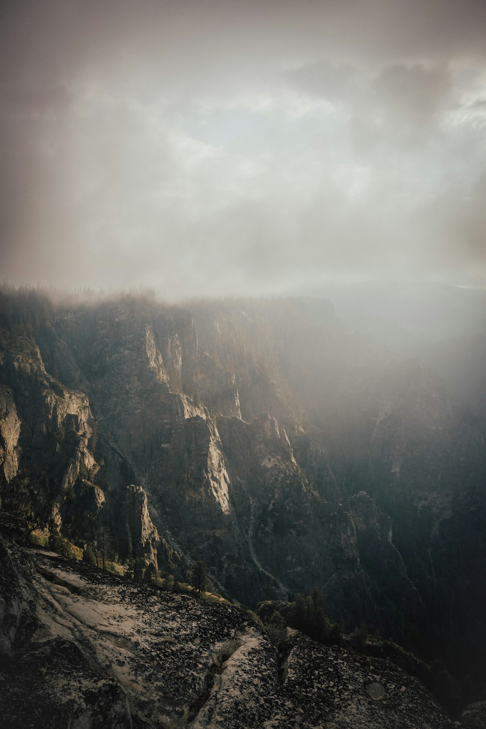 montagne rocheuse brune sous des nuages blancs