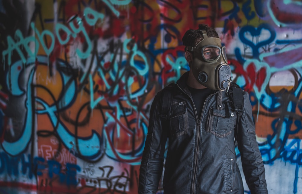 man in black leather jacket wearing gas mask