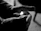 Close-up of a firefighter’s hands adjusting ignisguard gloves with flames softly glowing in the background.