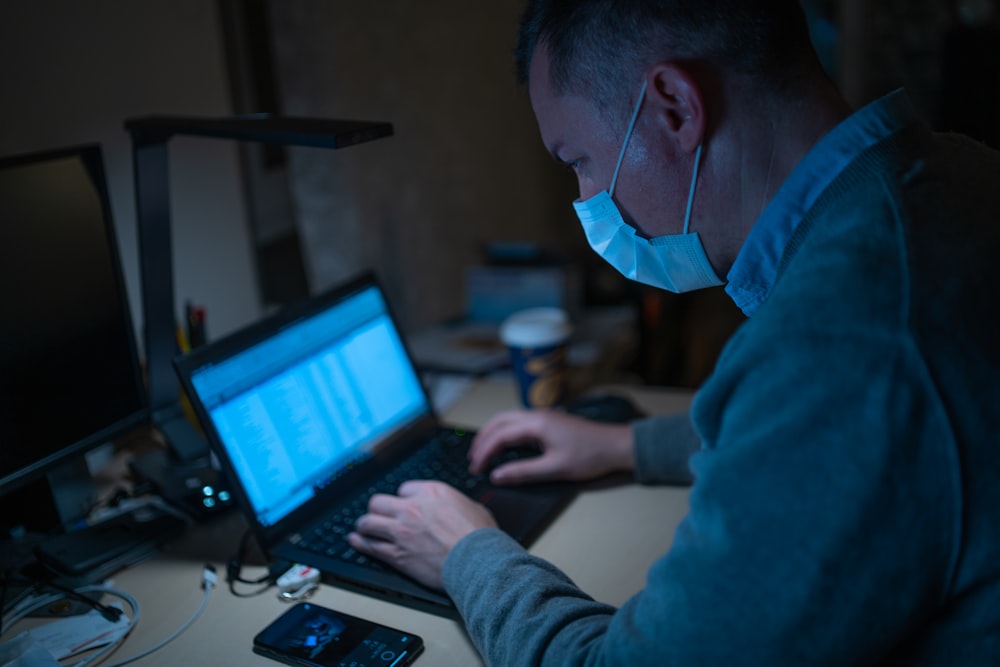 man in blue hoodie using laptop computer