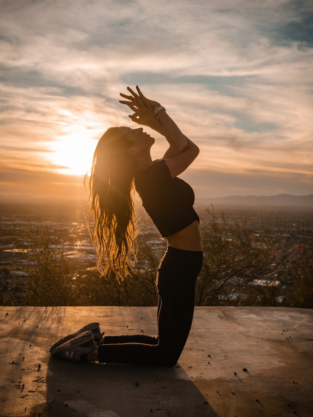 woman in black tank top and black pants standing on seashore during sunset