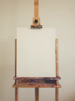 Close-up of a blank white canvas resting on an easel in a quiet studio.