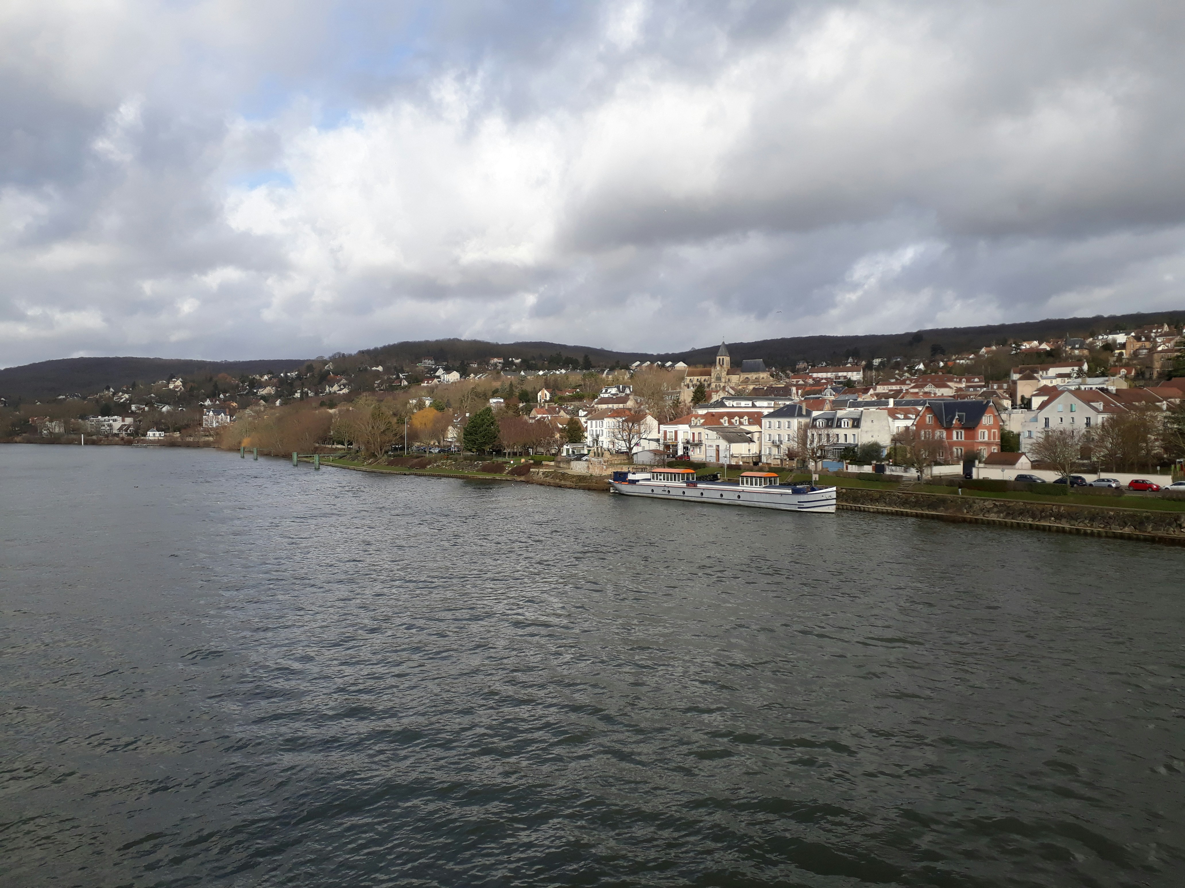 white boat on sea near city buildings under white clouds during daytime