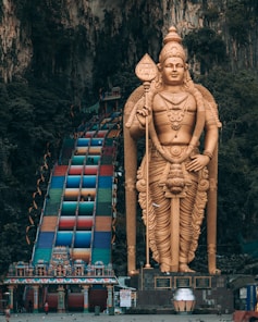gold statue of man on top of building