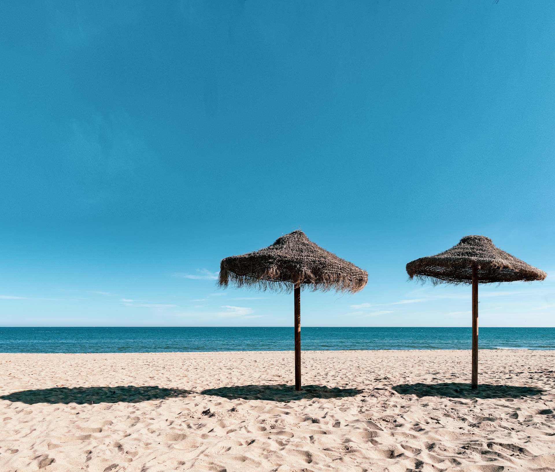 brown beach umbrellas on beach during daytime