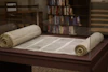 white scroll on brown wooden table in library 