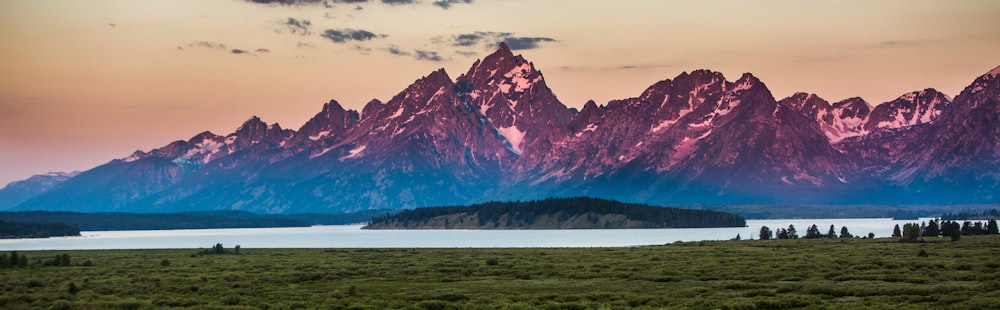 snow covered mountain near body of water during daytime