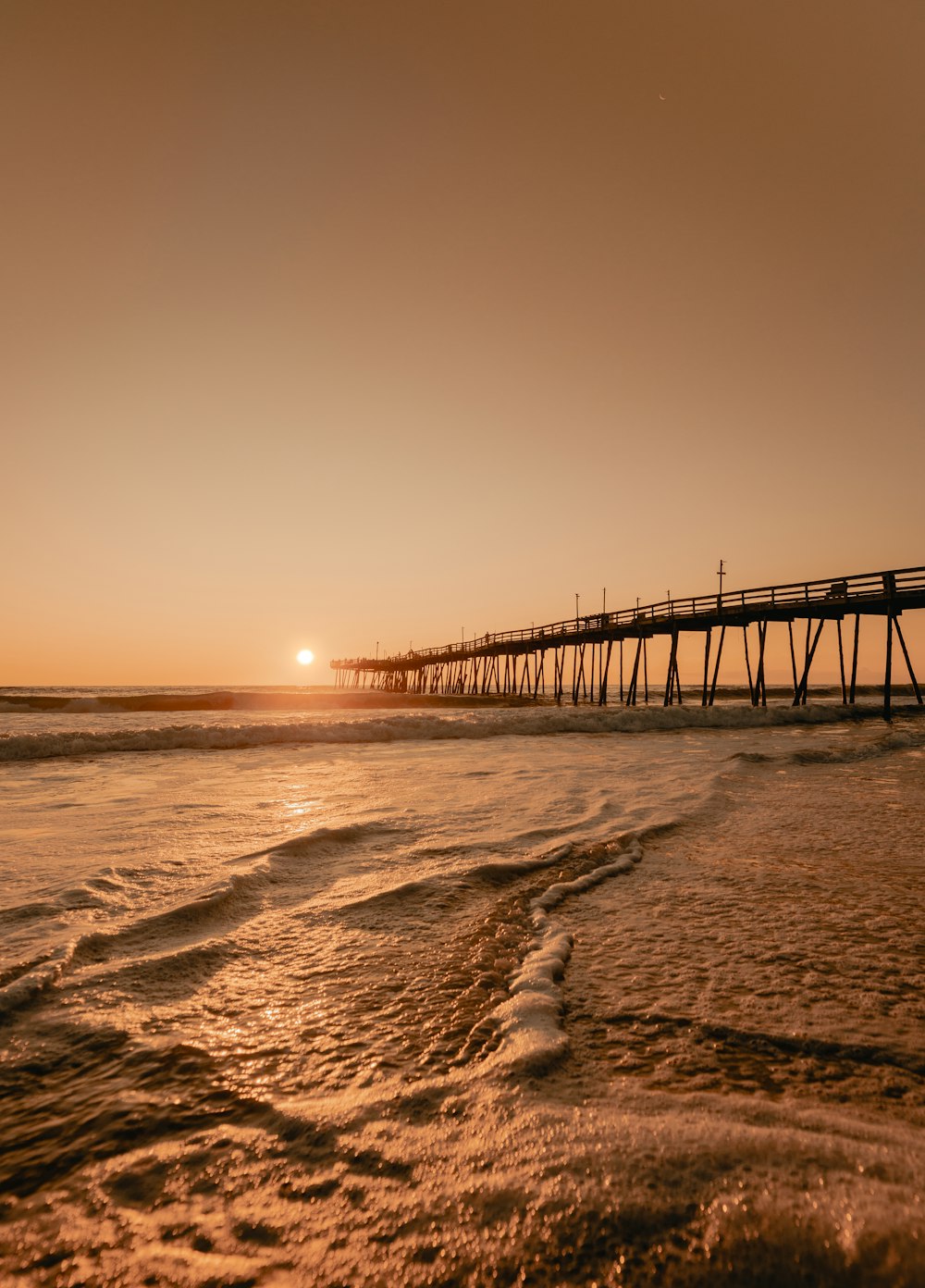 Braunes Holzdock auf See bei Sonnenuntergang