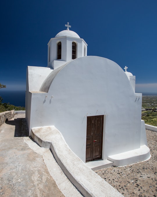 white concrete building under blue sky during daytime in Oia Greece