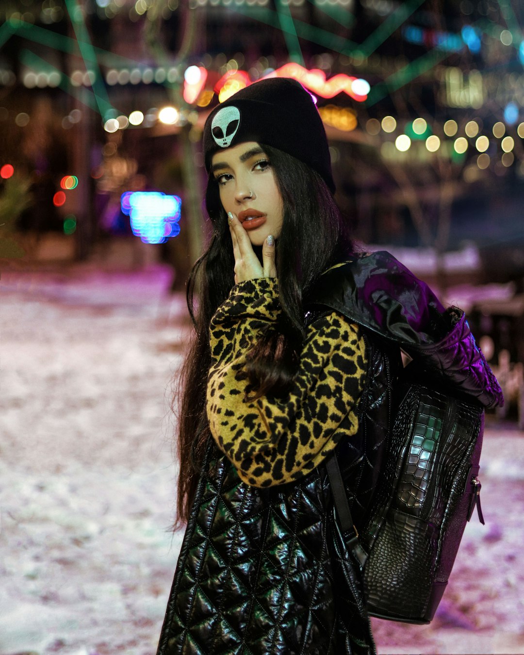 woman in black and brown leopard print coat and black knit cap standing on road during