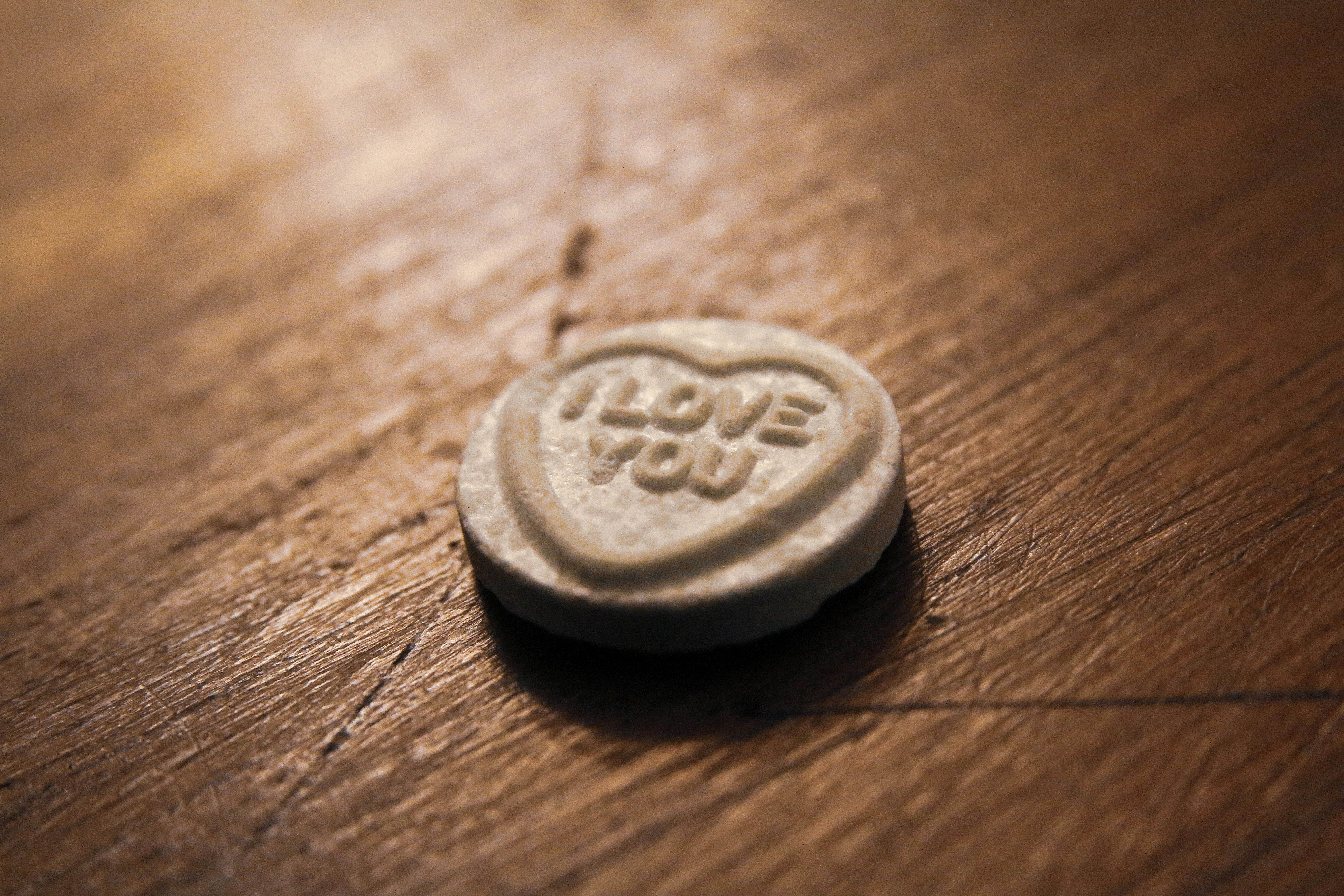 silver round coin on brown wooden table