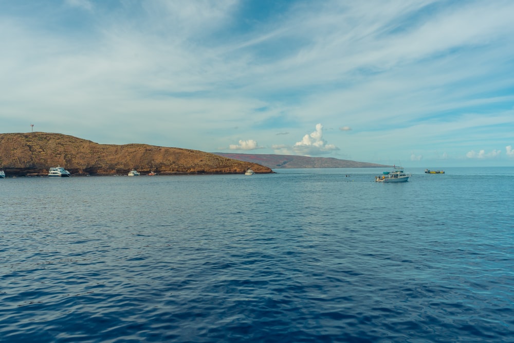 white ship on sea near island under blue sky during daytime