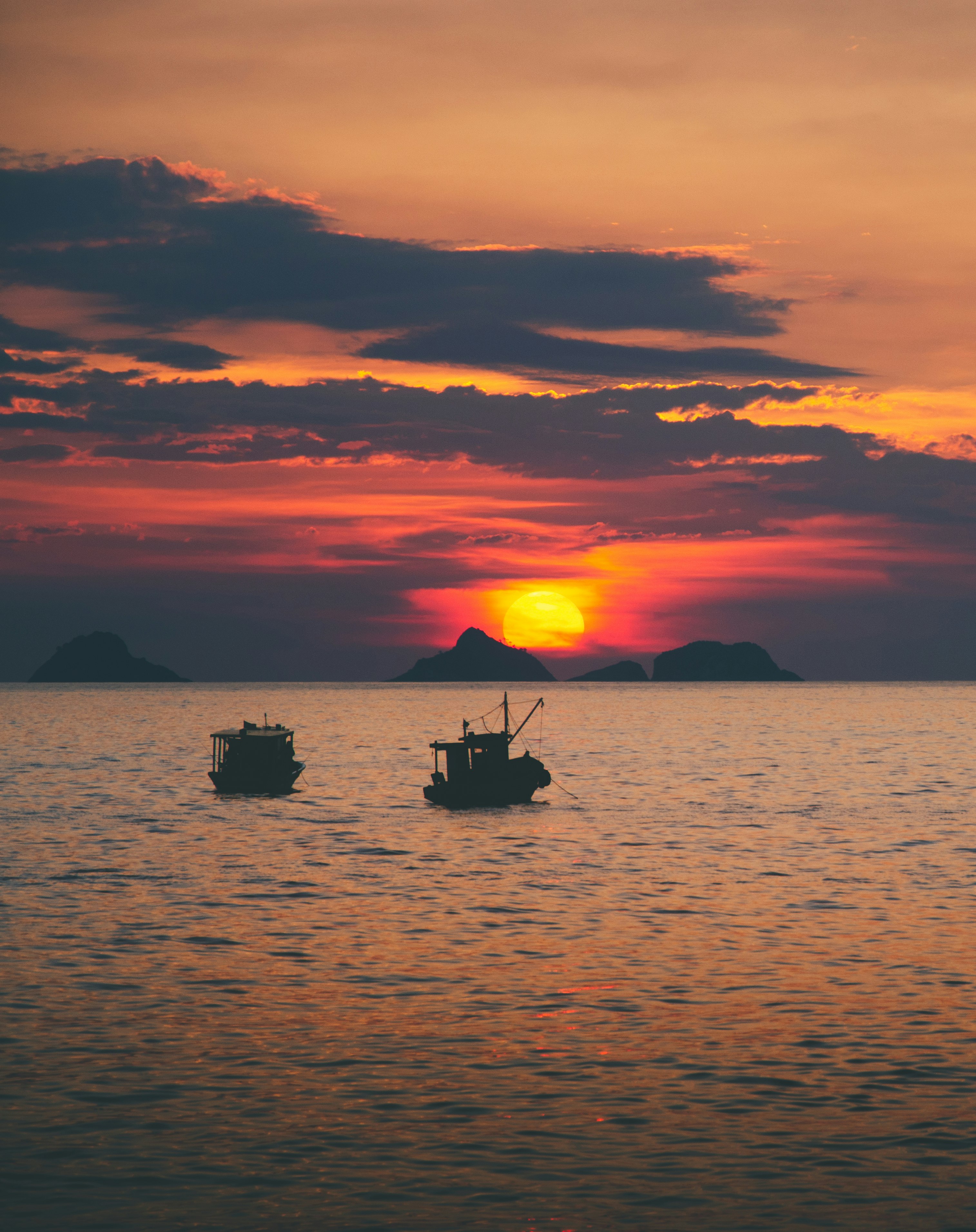 silhouette of boat on sea during sunset