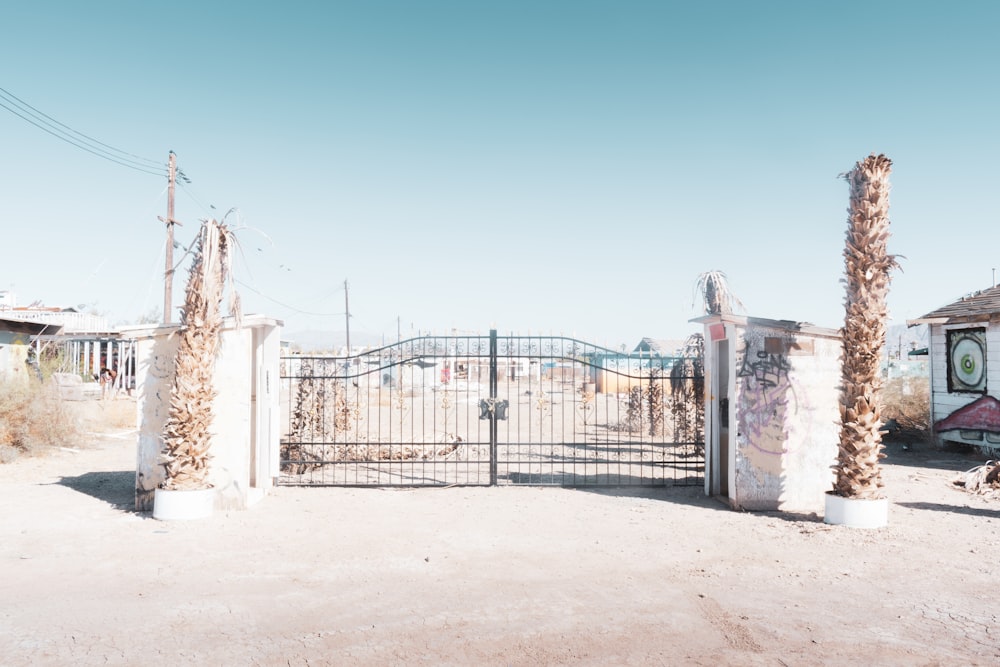 black metal gate near white concrete wall