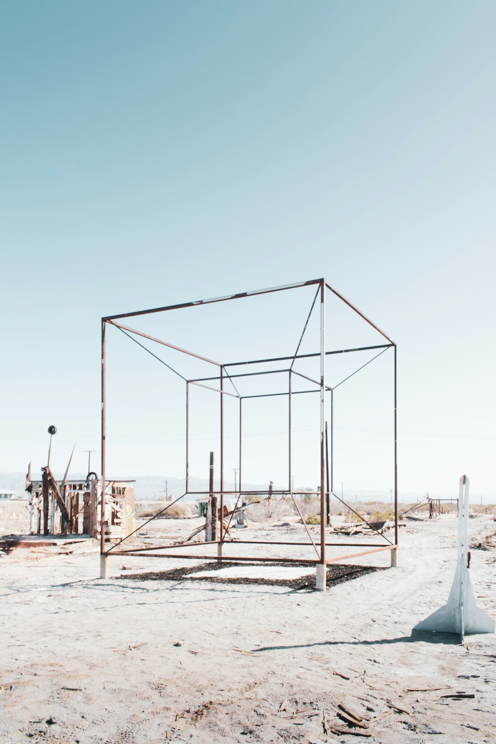 white metal frame on white sand during daytime