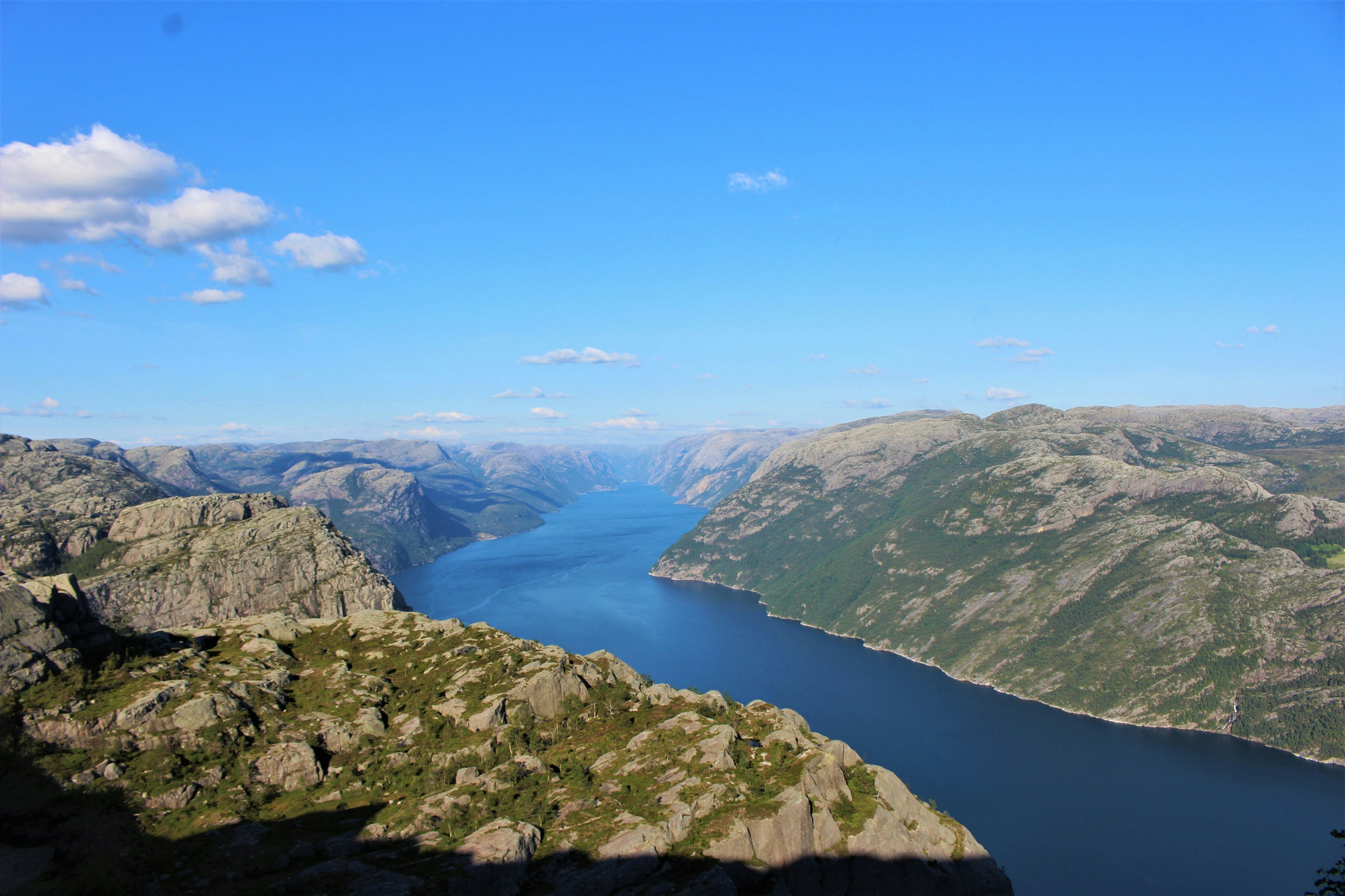 green mountains near lake under blue sky during daytime