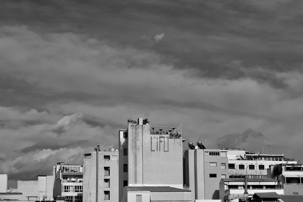 흐린 하늘 아래 콘크리트 건물의 회색조 사진