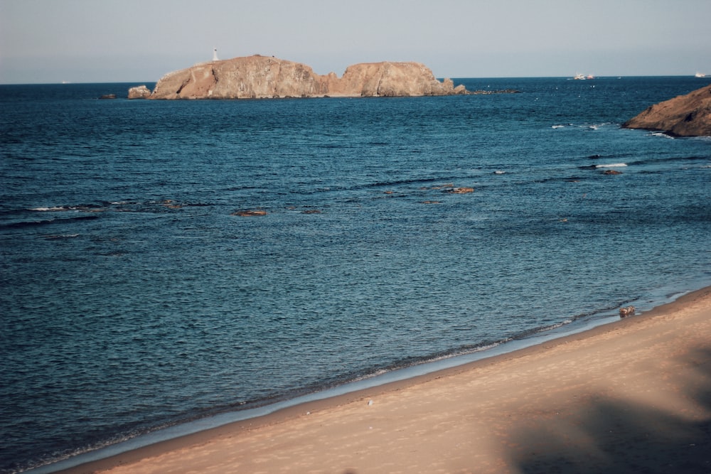 brown rock formation on blue sea water during daytime