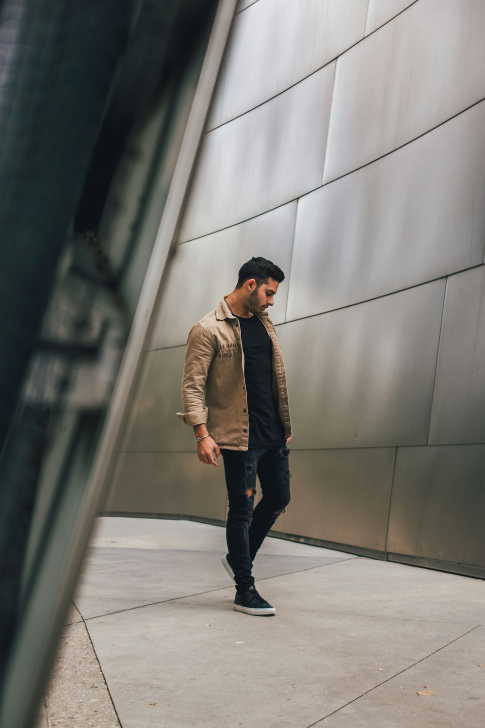 man in brown jacket standing on hallway