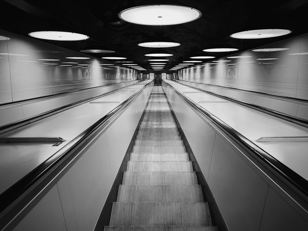 black and white escalator in a tunnel