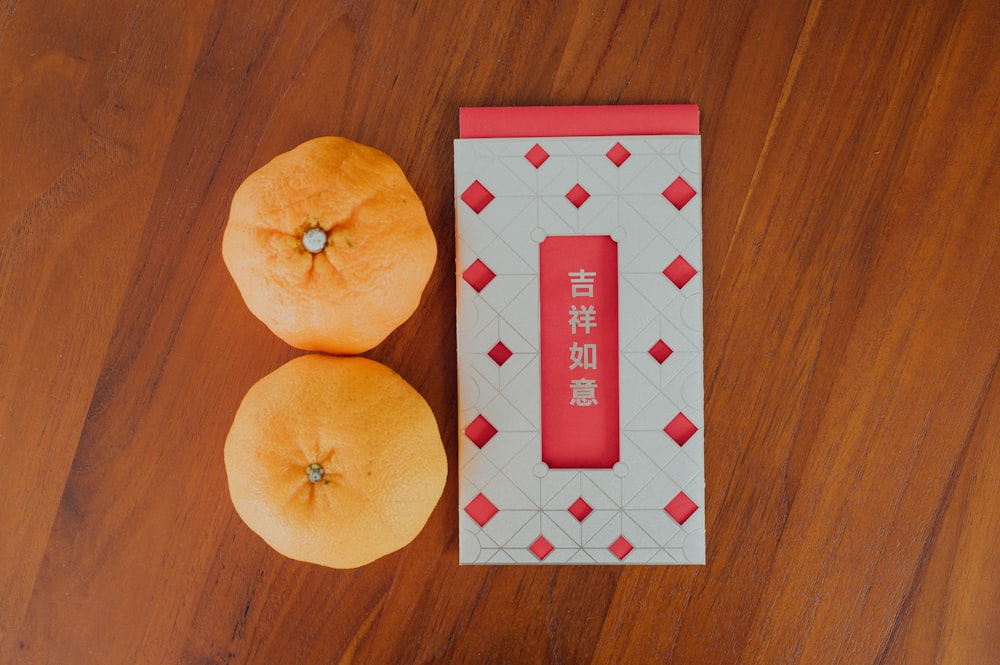赤と白の市松模様のテーブルにオレンジ色の果物