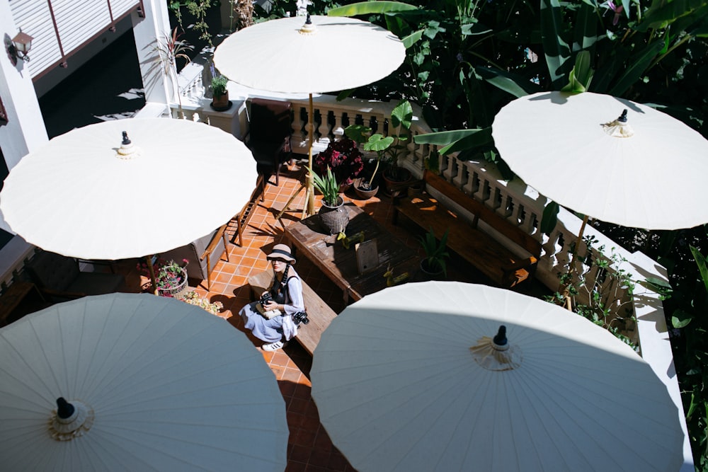 people sitting on brown wooden chairs under white umbrella during daytime