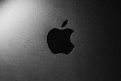 Close-up of a glowing gradient logo against a deep matte black background.