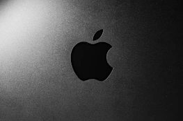 Close-up of a glowing gradient logo against a deep matte black background.