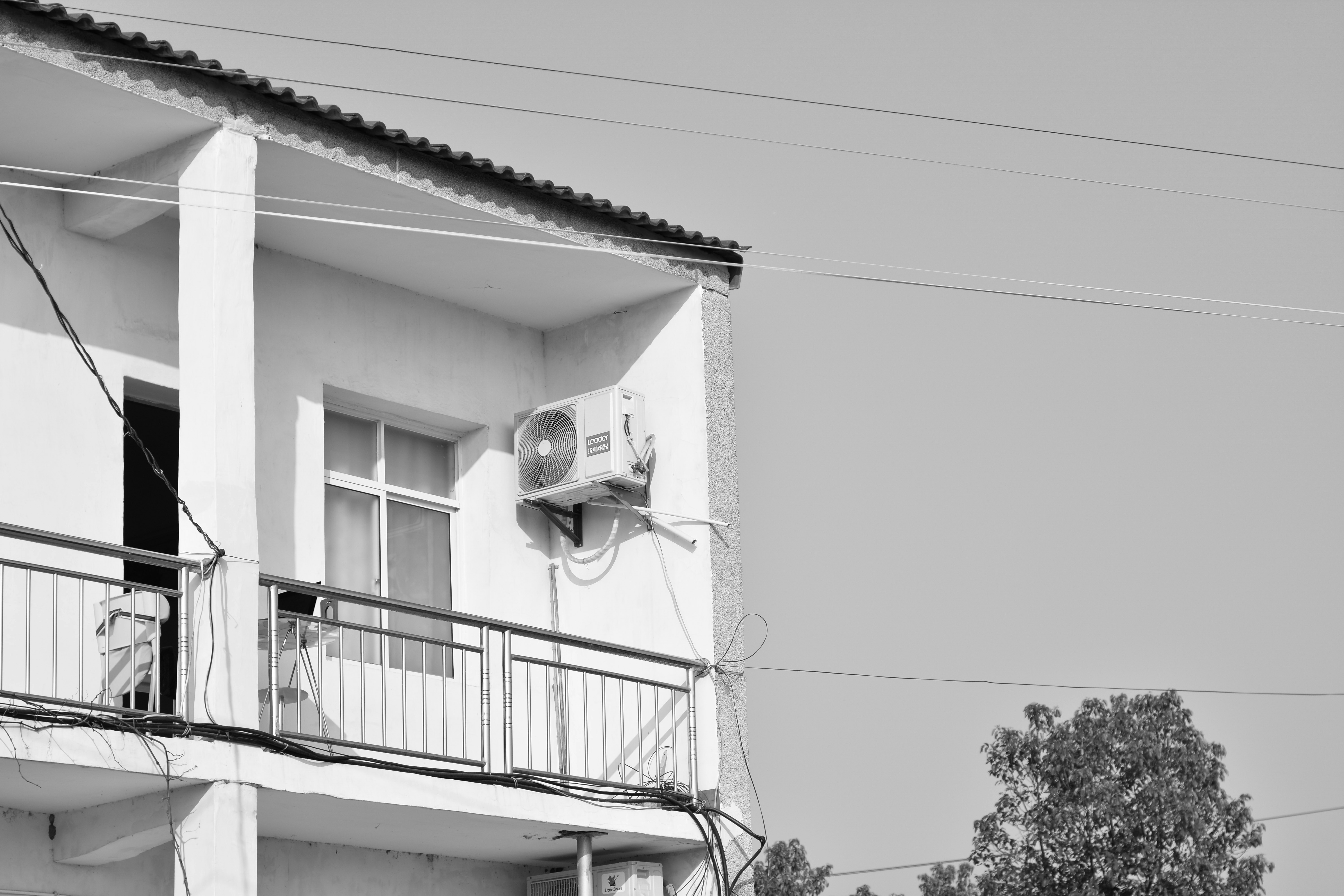 a black and white photo of a building with a balcony