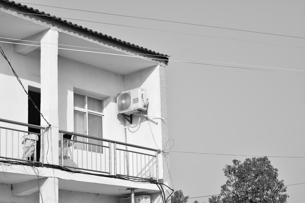 a black and white photo of a building with a balcony