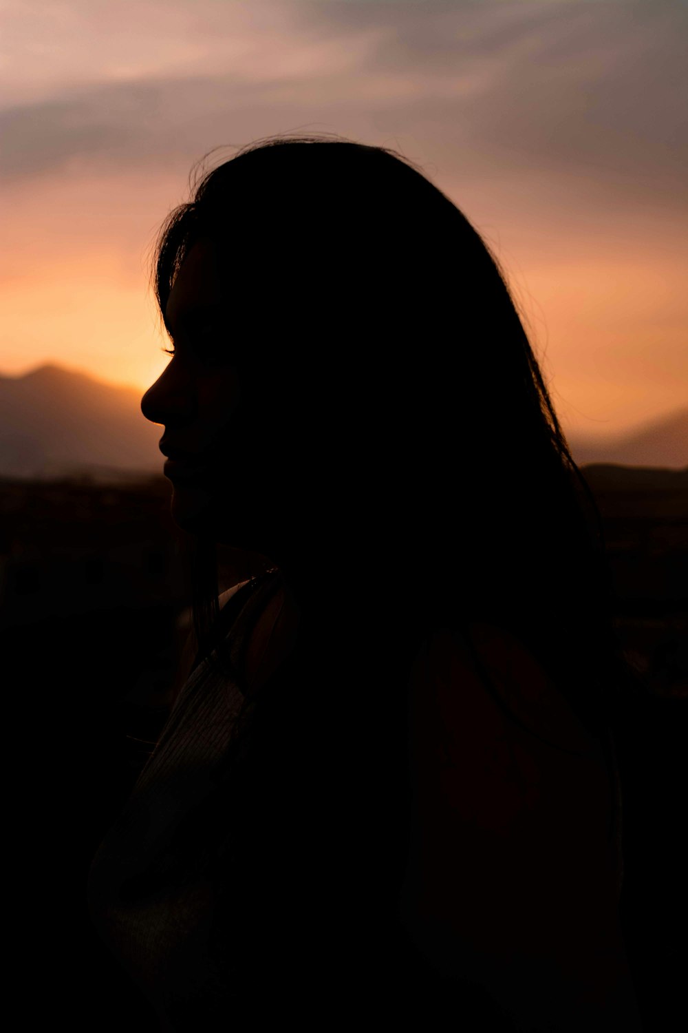 woman in black shirt looking at the sunset